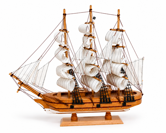 Wooden model ship with white sails on a white background