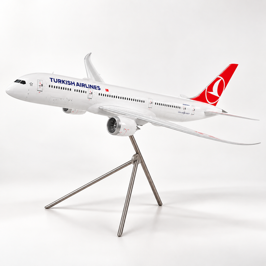 A scale model of a Turkish Airlines passenger airplane displayed on a metal tripod stand against a clean white studio background.