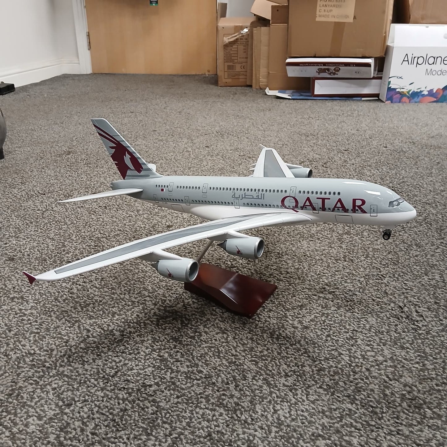 Model airplane with Qatar Airways livery on a carpeted floor