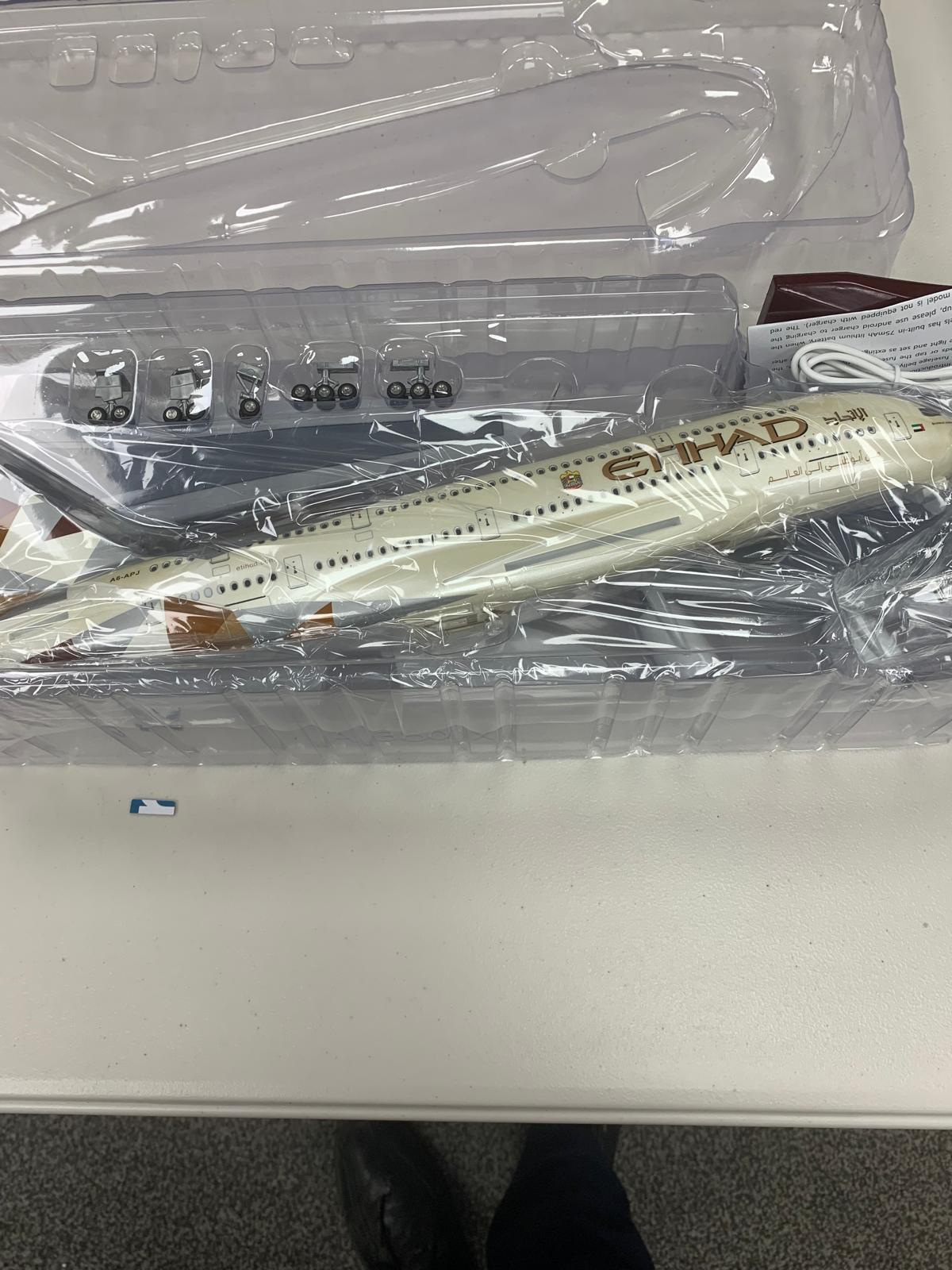Model airplane in a clear plastic case on a white surface