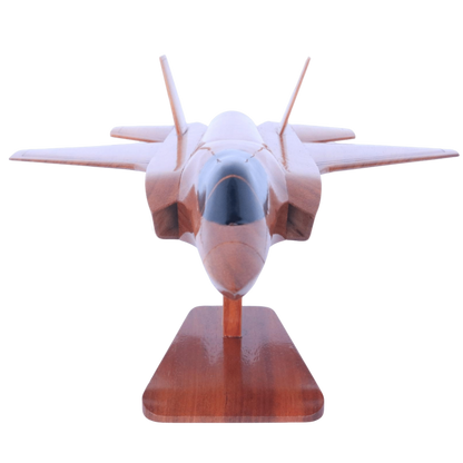 Model of a fighter jet on a wooden stand with a white background