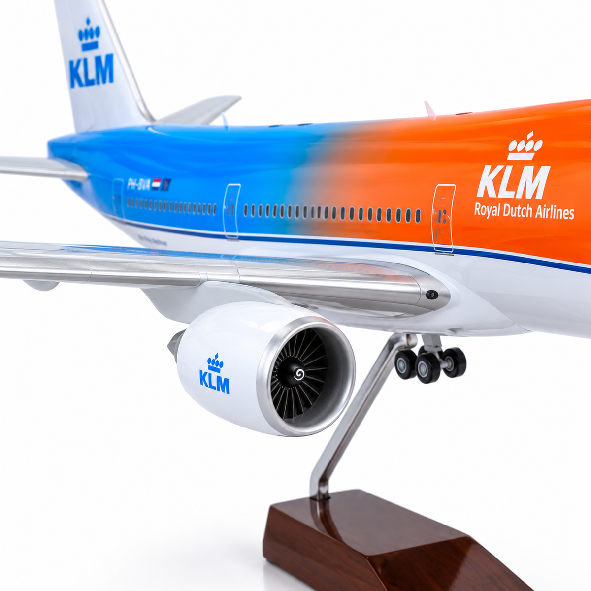 A scale model of a KLM Royal Dutch Airlines passenger jet, shown from a side-rear angle mounted on a wooden display stand against a clean white background.