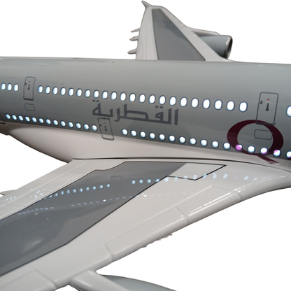 Model of an airplane with Qatar Airways logo on a white background with lights