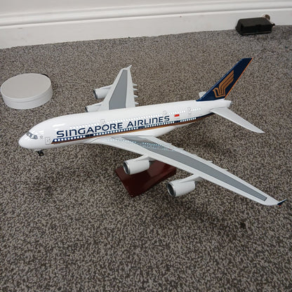 Model of a A380 Singapore Airlines airplane on a carpeted floor with lights on