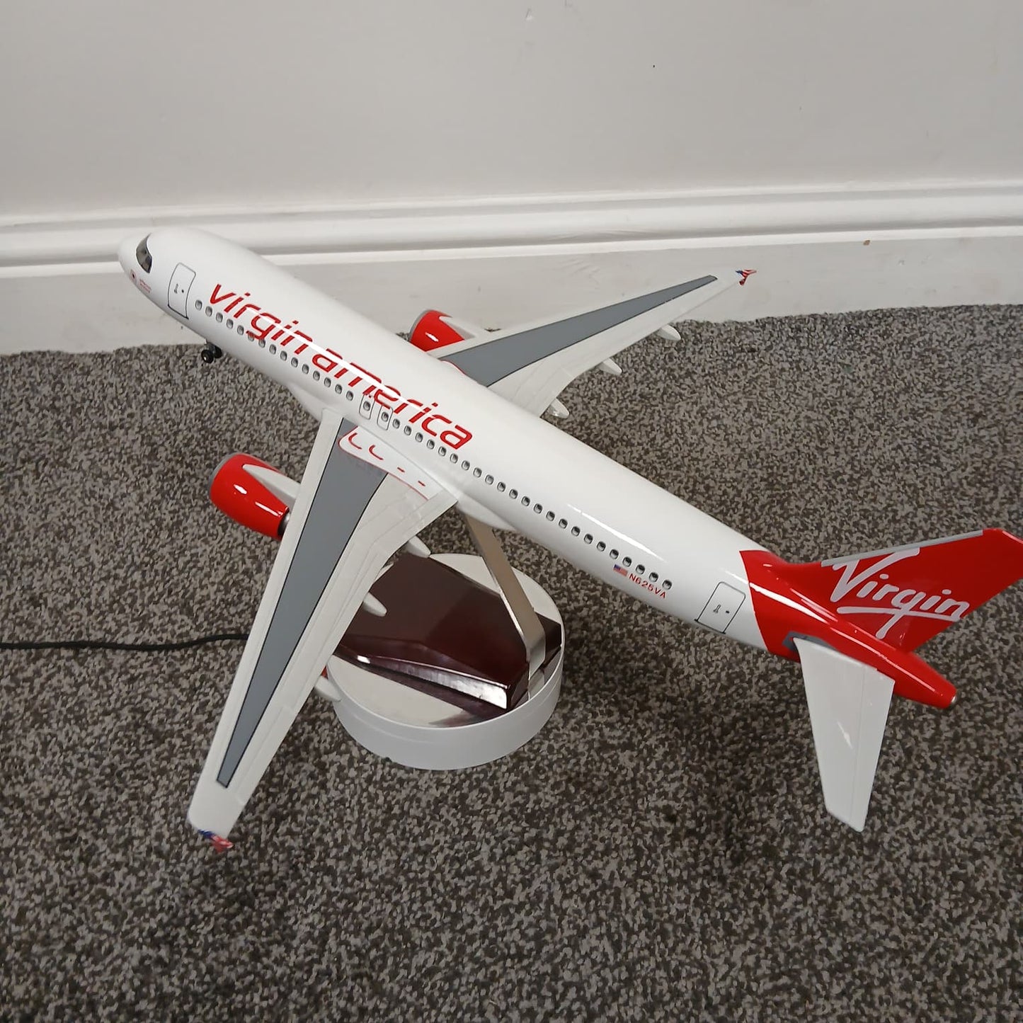 Model airplane with Virgin America branding on a carpeted floor.