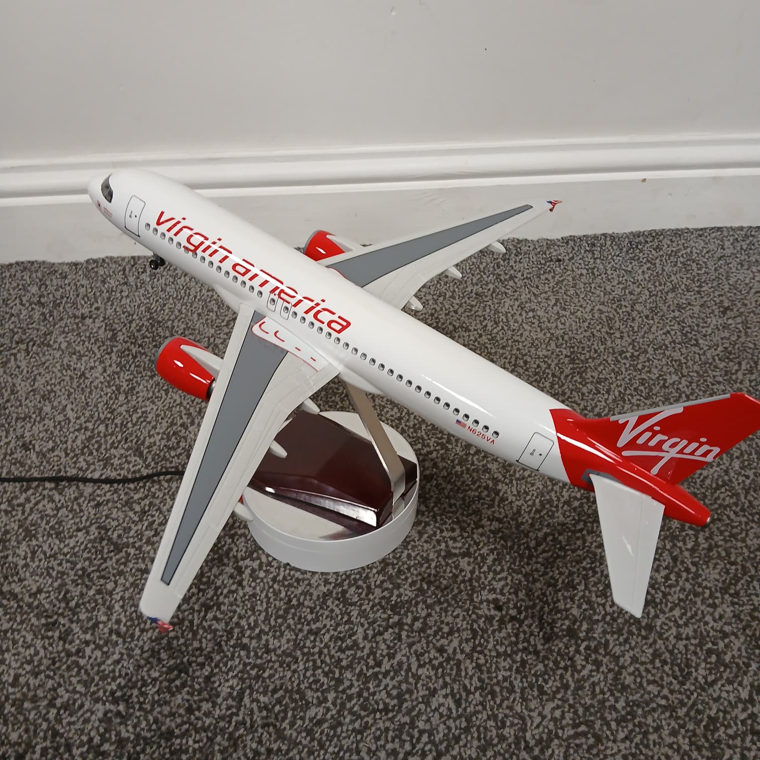 Model airplane with Virgin America branding on a carpeted floor.