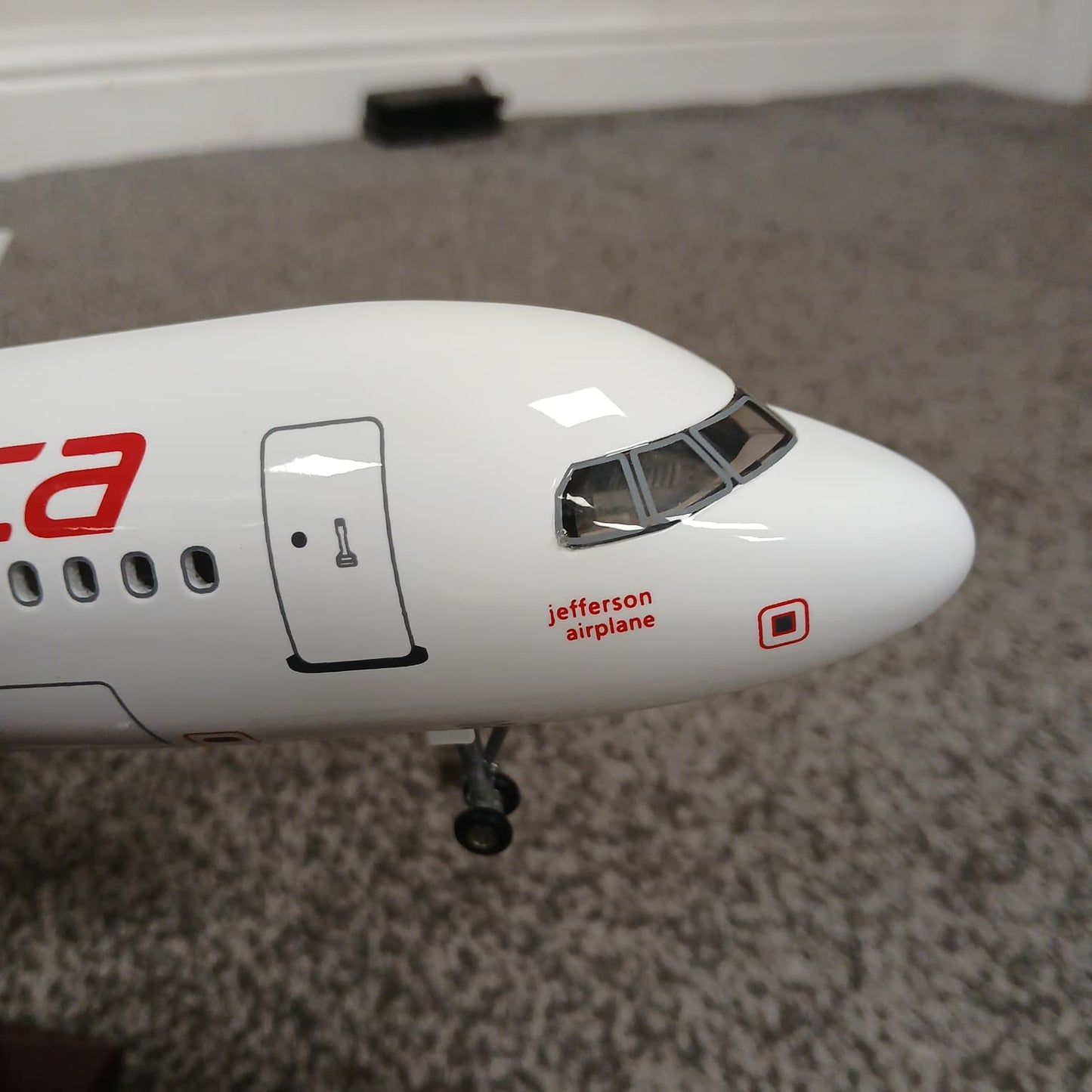 Model airplane with 'Jefferson Airplane' branding on a carpeted floor
