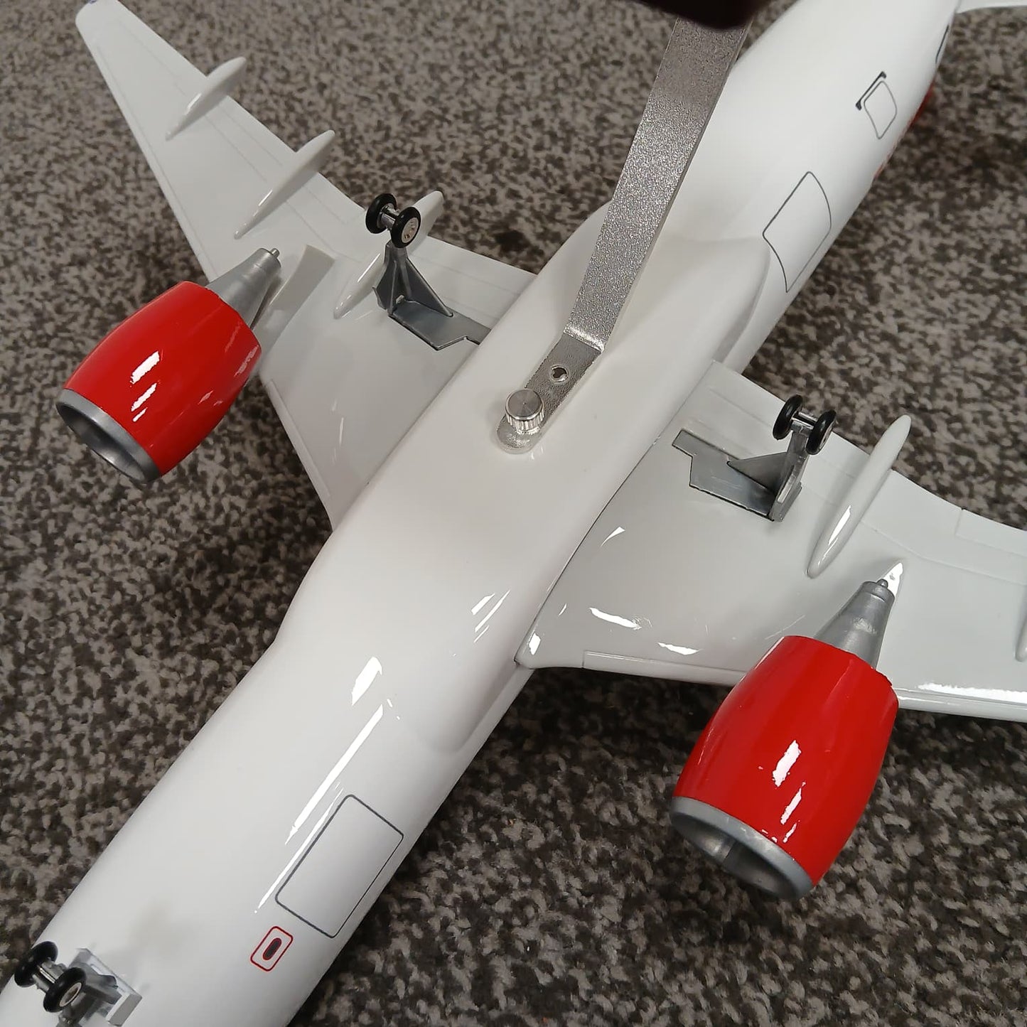 Model airplane with red engines on a textured surface