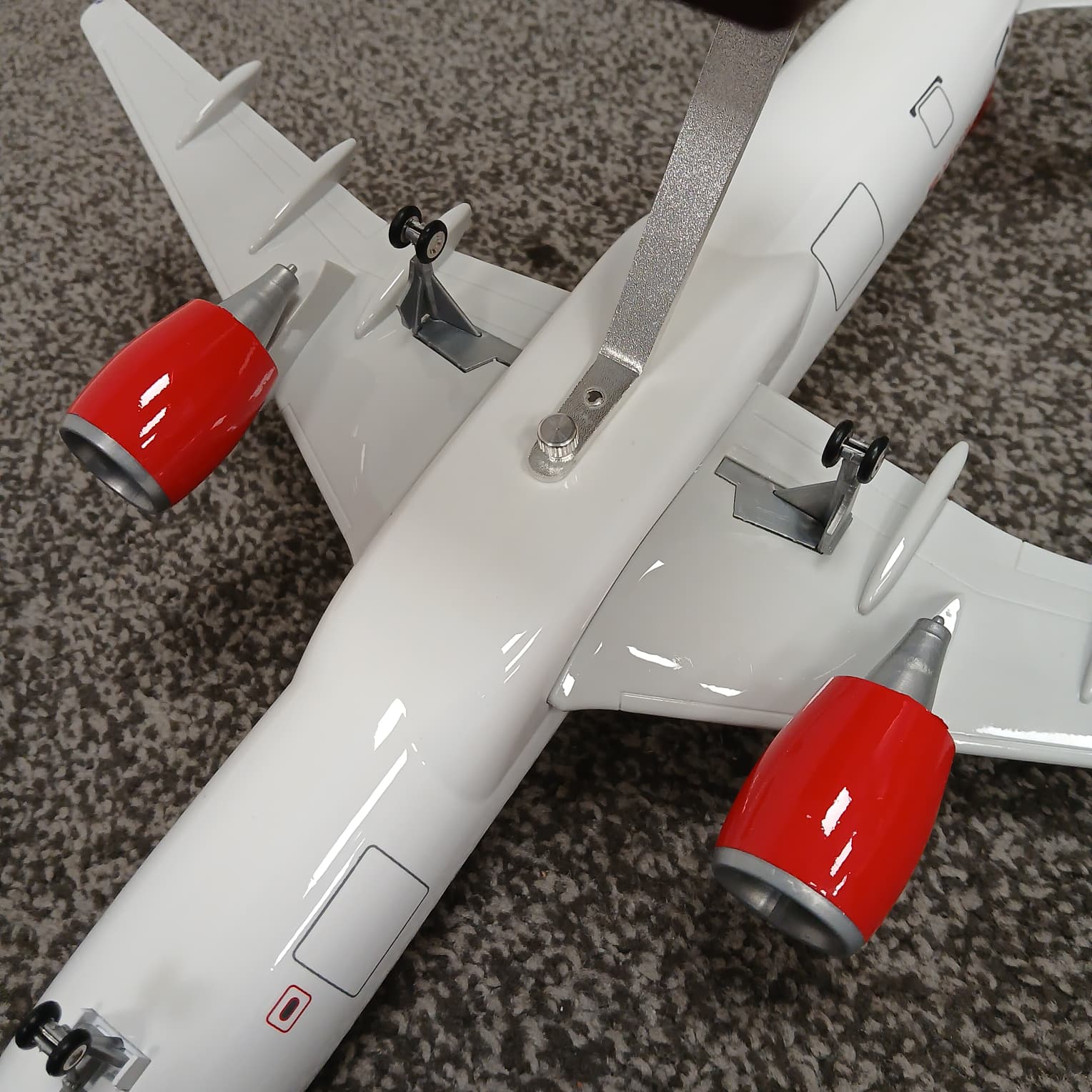 Model airplane with red engines on a textured surface