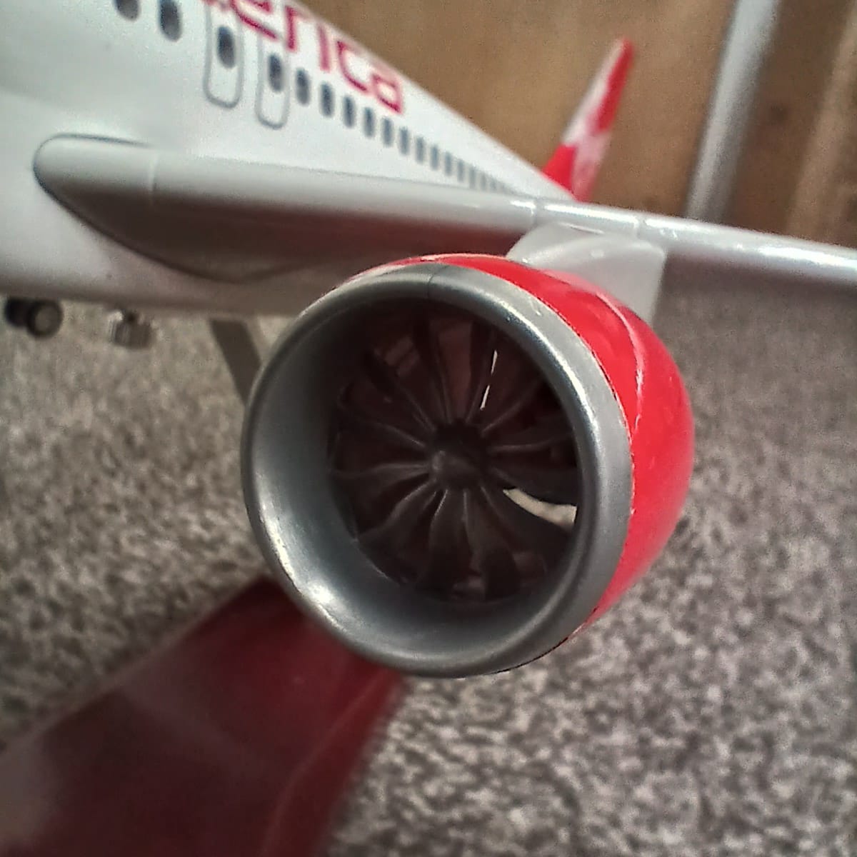Close-up of a red airplane engine on a carpeted floor