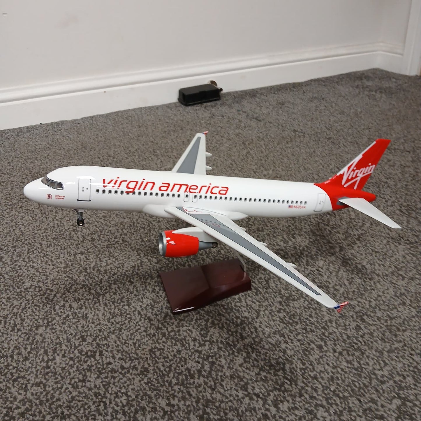 Model airplane with Virgin America branding on a carpeted floor.